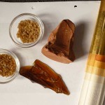 trockene Leim-Rohstoffe, Bolus und eine kreidegrundierte, mit Bolus versehene Holzleiste